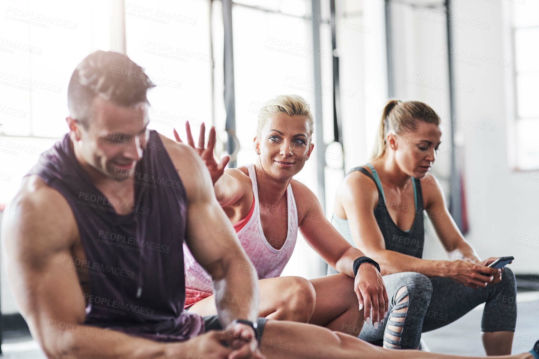 Buy stock photo Shot of a group of people taking a break together after a workout at the gym