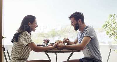 Buy stock photo Shot of a happy young couple having a leisurely breakfast together on the balcony at home