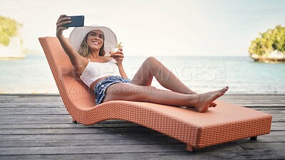 Buy stock photo Selfie, travel and woman with water, summer and happiness on a sun lounger, cocktail and tropical island. Female person, girl or happy tourist on a break, social media and drink to relax and cheerful