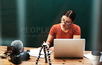 Buy stock photo Cropped shot of an attractive young businesswoman sitting alone at her desk and writing in her notebook