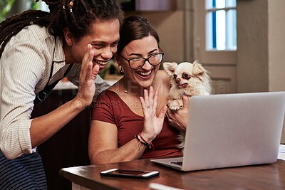 Buy stock photo Cropped shot of a cheerful young couple having a video call while waving at the camera and holding their dog at home