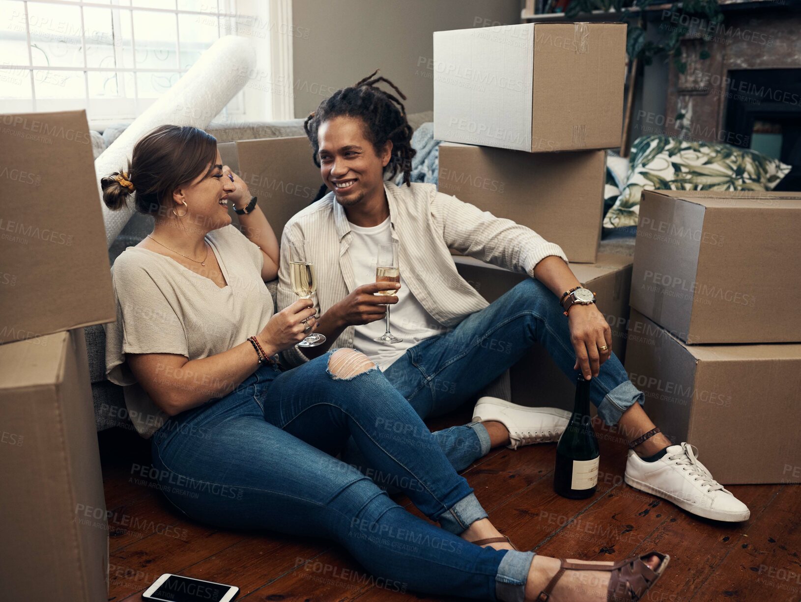 Buy stock photo Shot of a happy young couple having champagne to celebrate their new home