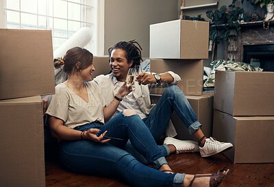 Buy stock photo Shot of a happy young couple having champagne to celebrate their new home