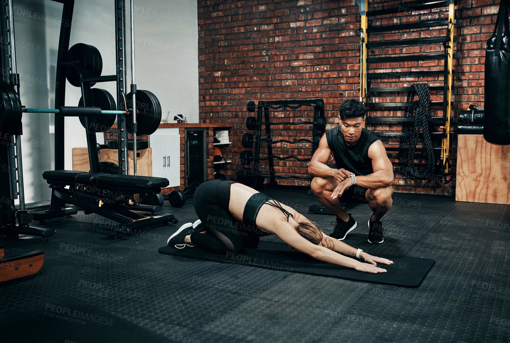 Buy stock photo Shot of a young woman working out with her personal trainer