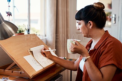 Buy stock photo Shot of a young woman drinking coffee while sketching at home