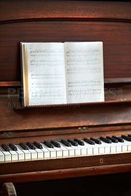 Buy stock photo Old vintage piano with musical notes at a classical music festival. An antique wooden keyboard with a composition book ready for a melody to be created in an art gallery. A classic musical instrument