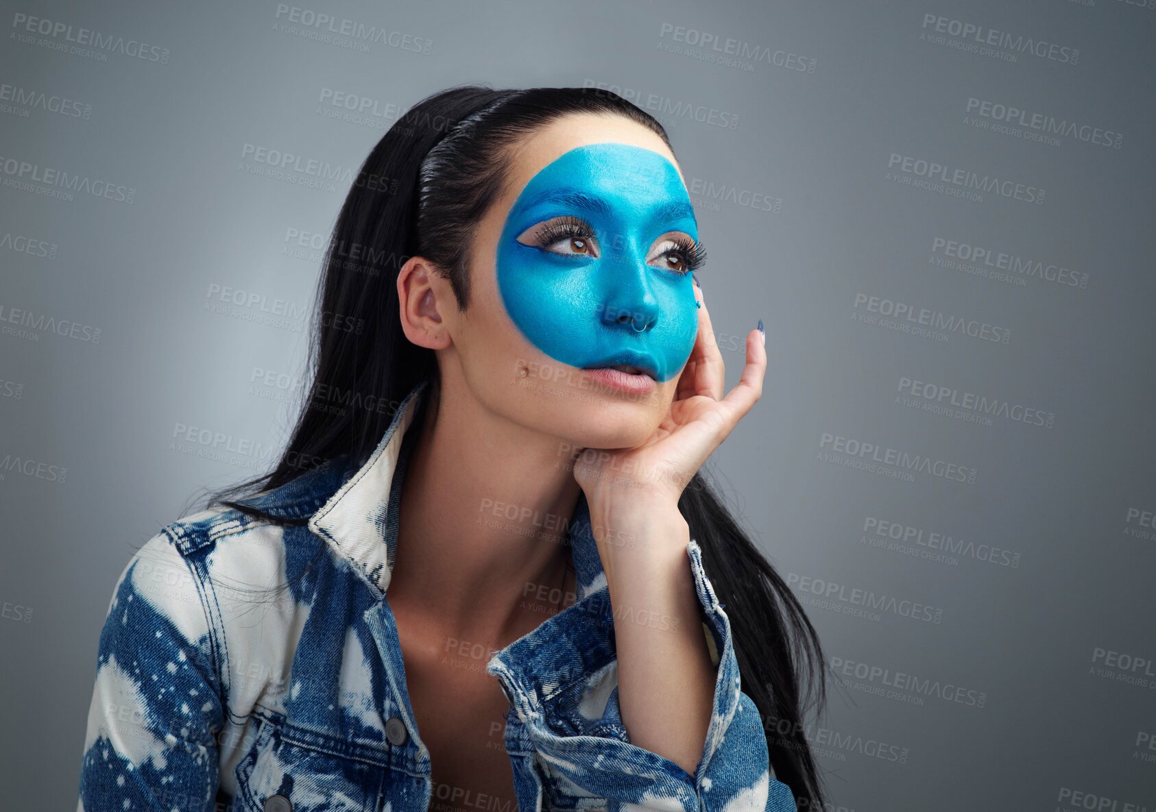 Buy stock photo Studio shot of a beautiful young woman looking thoughtful while posing against a grey background