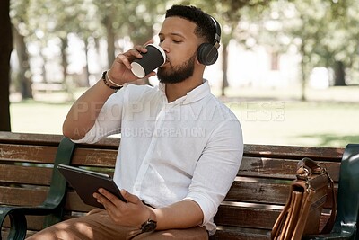 Buy stock photo Business man, coffee and headphones outdoor with a tablet on a park bench for a break with internet. Male entrepreneur person in nature while streaming and listening to music on a audio app to relax