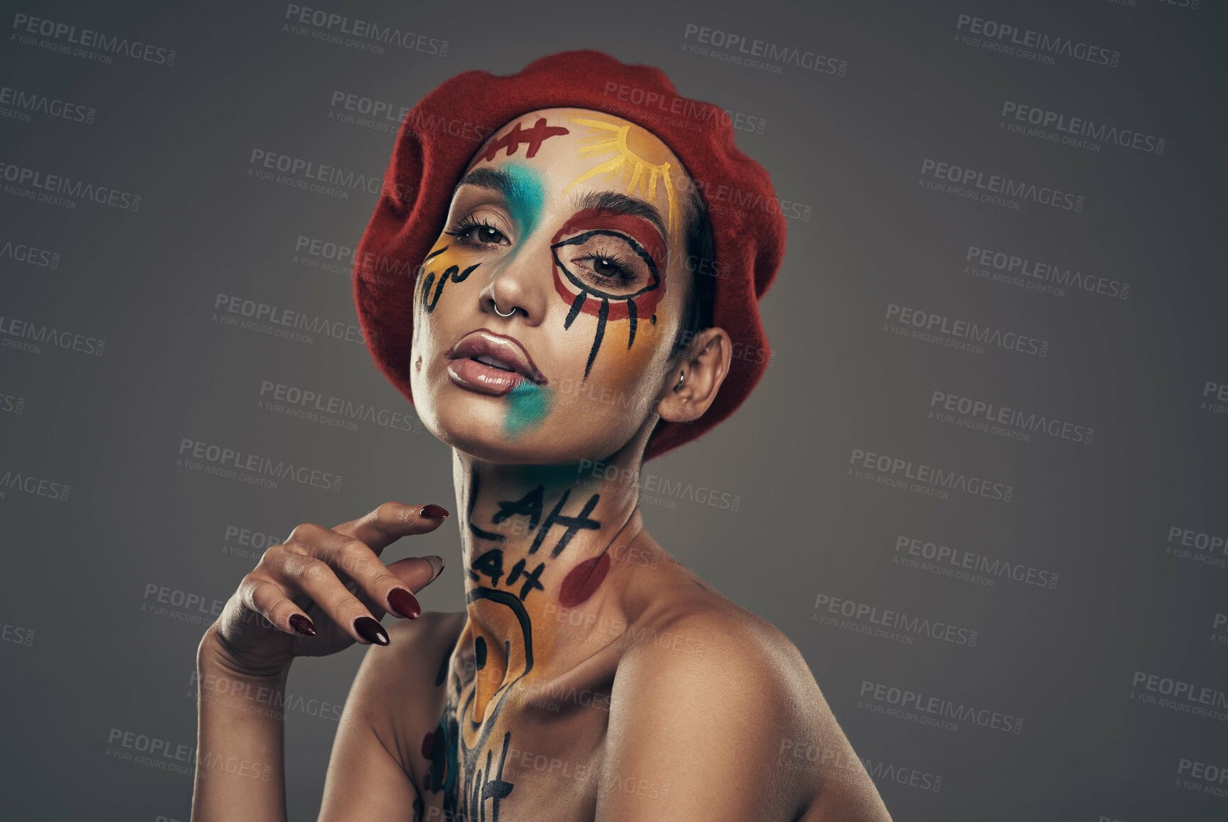 Buy stock photo Studio shot of a young woman posing with paint on her face on a grey background