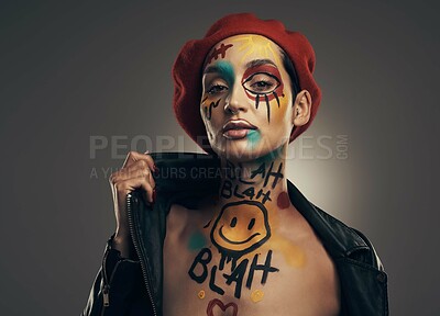 Buy stock photo Studio shot of a young woman posing with paint on her face on a grey background