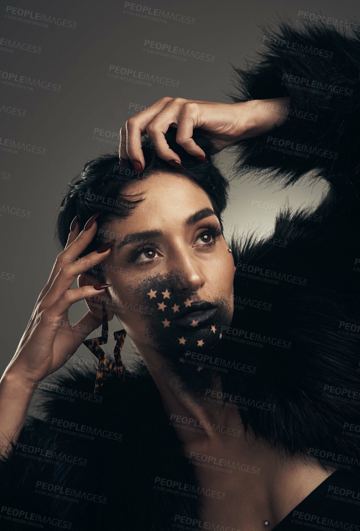 Buy stock photo Studio shot of a young woman posing with paint on her face on a grey background