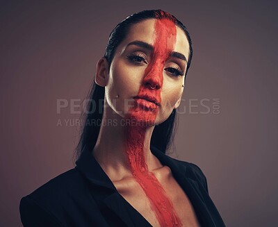 Buy stock photo Studio shot of a young woman posing with paint on her face on a grey background