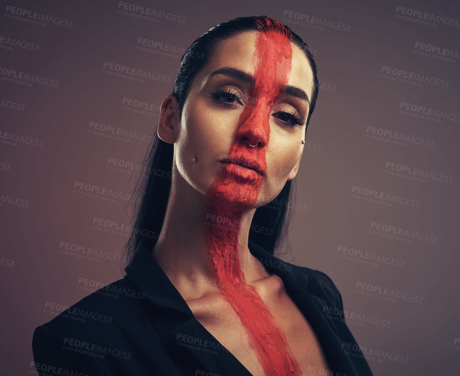 Buy stock photo Studio shot of a young woman posing with paint on her face on a grey background