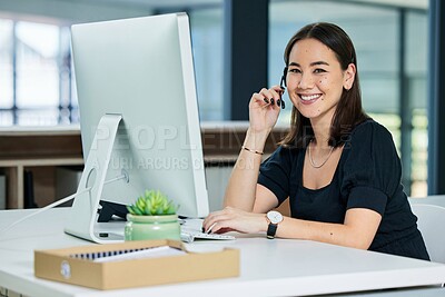 Buy stock photo Portrait shot of a young call centre agent on a call in an office