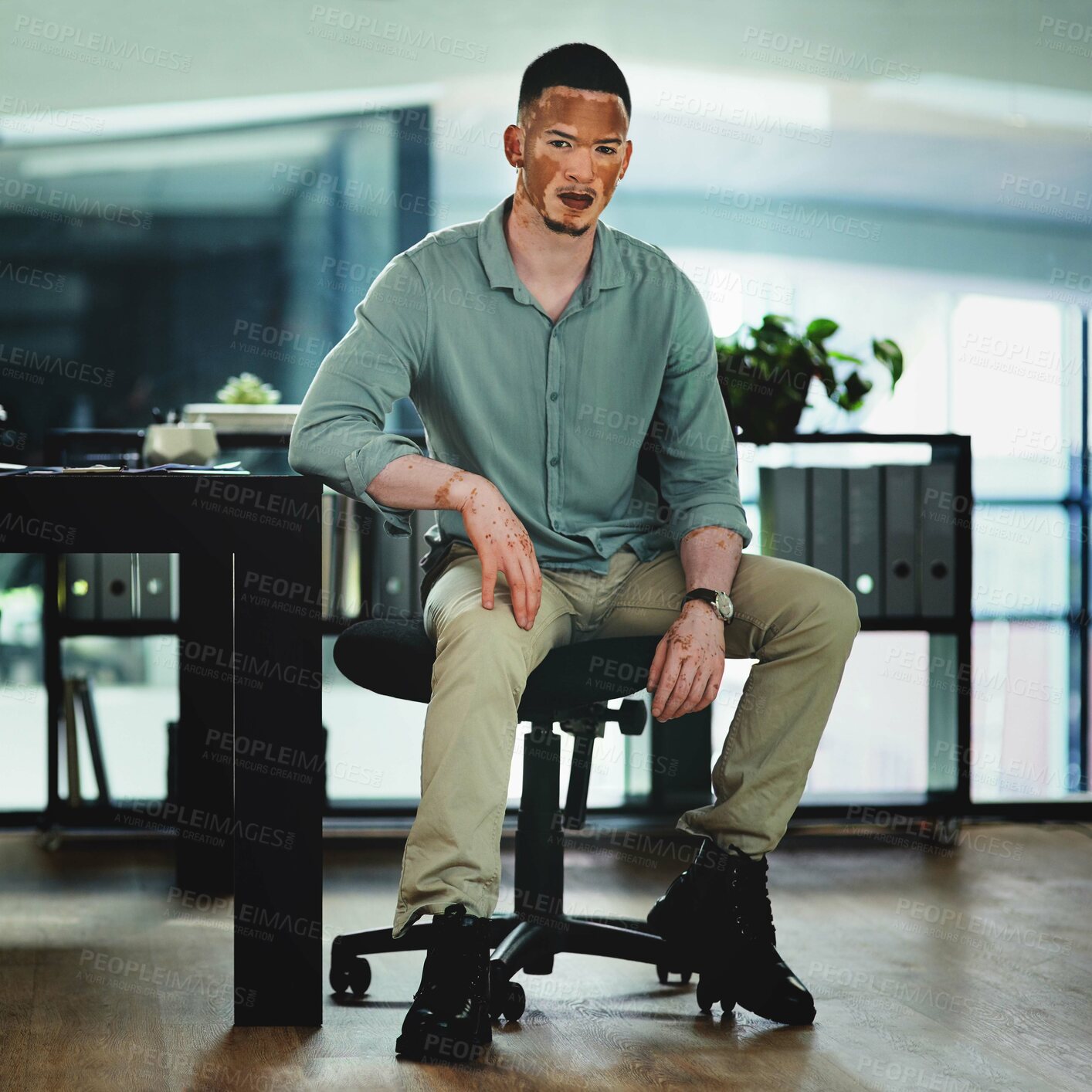 Buy stock photo Shot of a young businessman sitting at a desk in an office at work