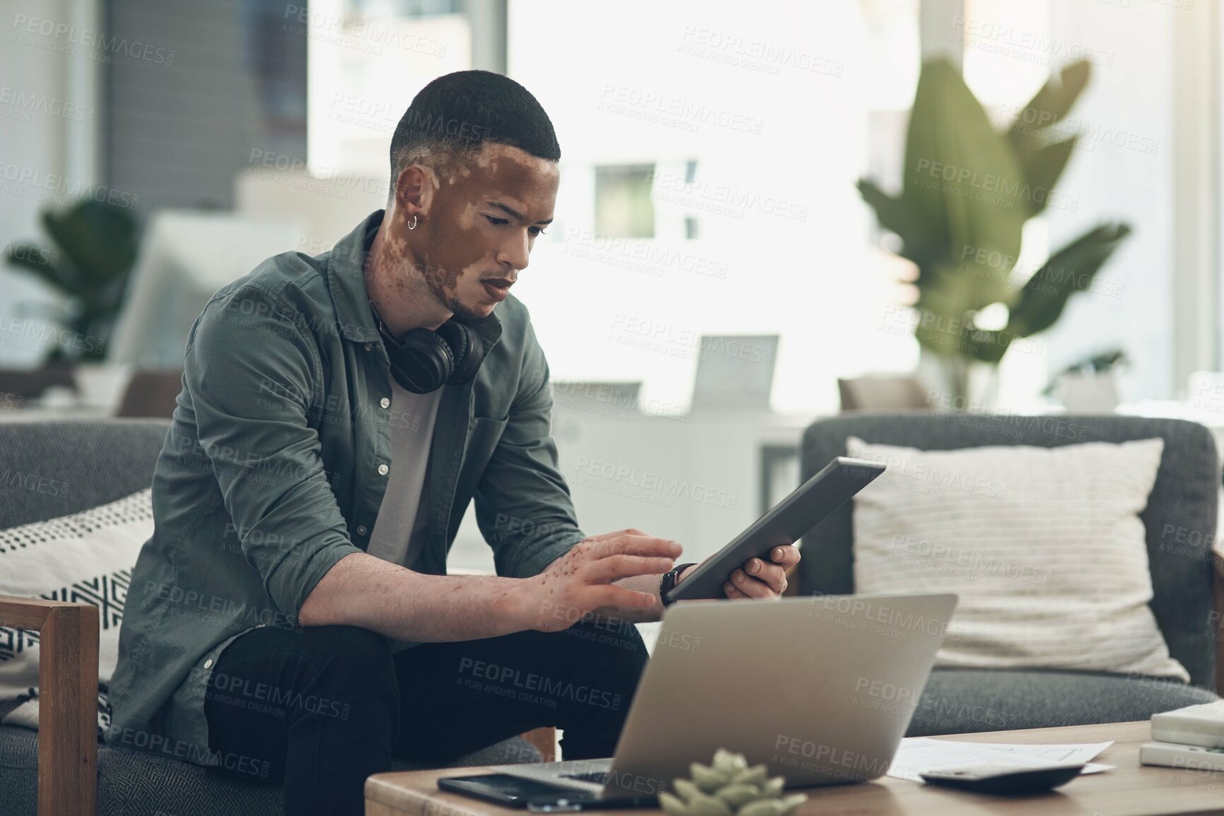 Buy stock photo Shot of a young business man using a tablet at work