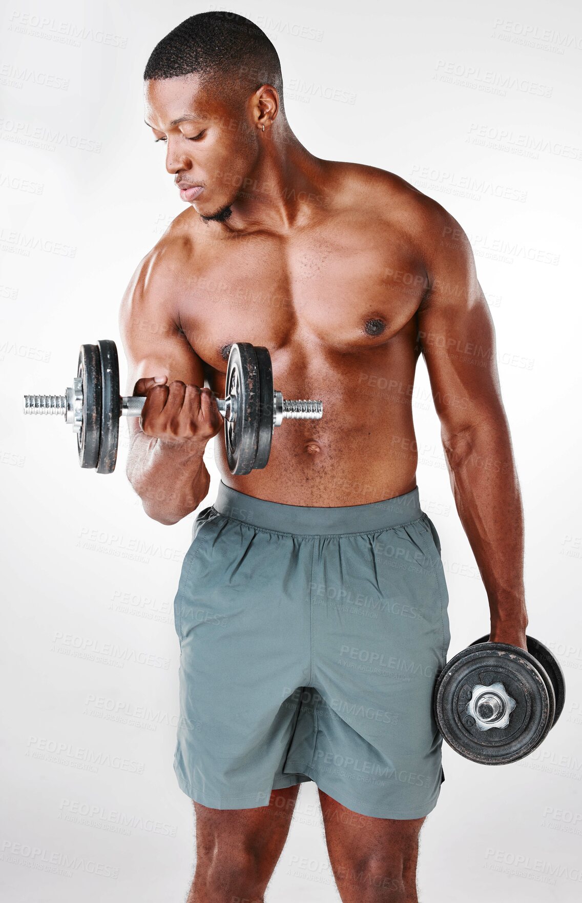 Buy stock photo Studio shot of a shirtless handsome young man using weights against a white