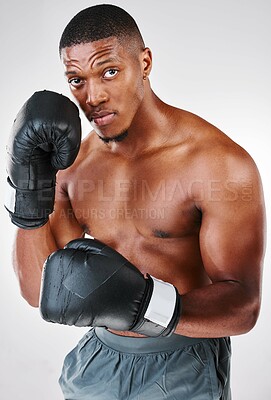 Buy stock photo Studio portrait of a young shirtless man posing with boxing gloves against a white background