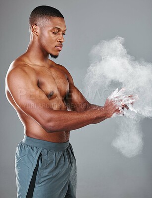 Buy stock photo Studio shot of a young shirtless man dusting his hands before working out against a grey background