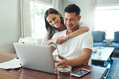 Buy stock photo Cropped shot of an affectionate young couple using a laptop to their household budget in the living room at home
