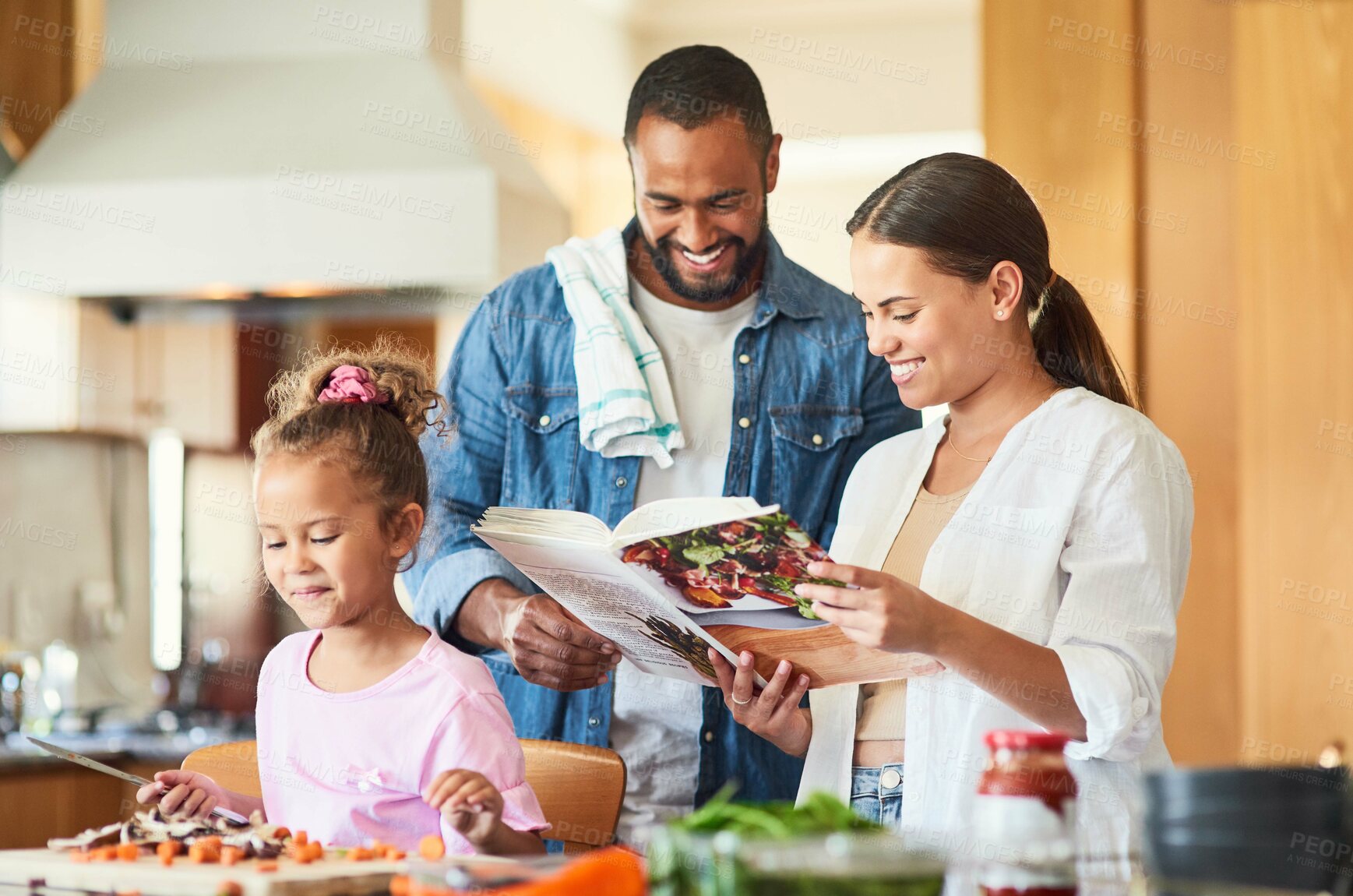 Buy stock photo Shot of a couple and their daughter cooking together in the kitchen at home