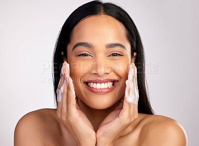 Buy stock photo Studio portrait of an attractive young woman washing her face against a pink background