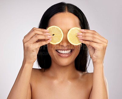Buy stock photo Studio shot of an attractive young woman posing with lemon slices over her eyes against a pink background