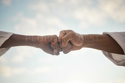 Buy stock photo Closeup shot of two unrecognisable people giving each other a fist bump outdoors