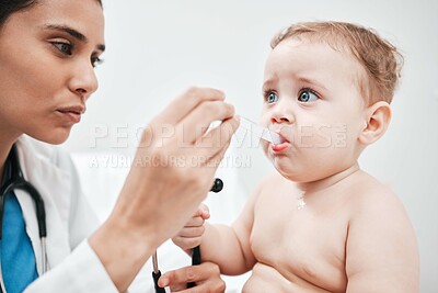 Buy stock photo Shot of a paediatrician giving her patient medication in a clinic