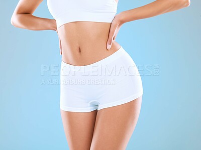 Buy stock photo Shot of an unrecognizable woman posing in her underwear against a blue background