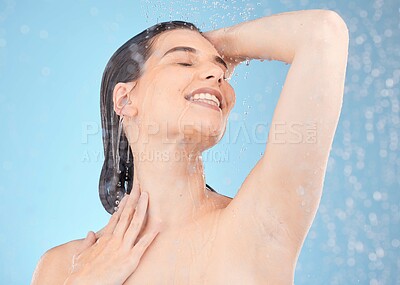 Buy stock photo Face, skincare and woman in shower in studio isolated on a blue background. Cleaning, water splash and female model from Canada bathing or washing for beauty, body care or wellness and healthy skin.