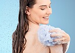 Skincare, back cleaning and woman in shower in studio isolated on a blue background. Face, water splash and female model from Canada bathing or washing with sponge for beauty, body care or wellness.