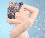 Shower, woman in studio and washing hair, shampoo and scalp for healthy skincare, body beauty or water splash on blue background. Happy model cleaning head with soap, foam or under water in hair care