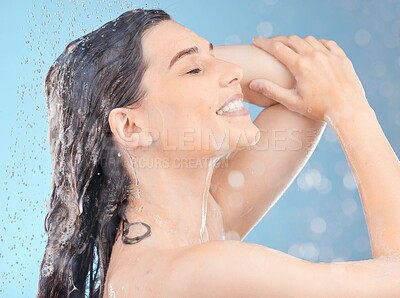 Buy stock photo Shower, cleaning and woman with water for hair in studio for skincare, body care and wellness on blue background. Self care, hydration and girl washing with shampoo, conditioner and hair products