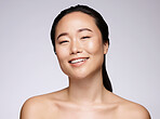 Portrait, beauty and skincare with a model asian woman in studio on a gray background for natural face treatment. Microblading, facial or wellness with an attractive young female posing for skin care