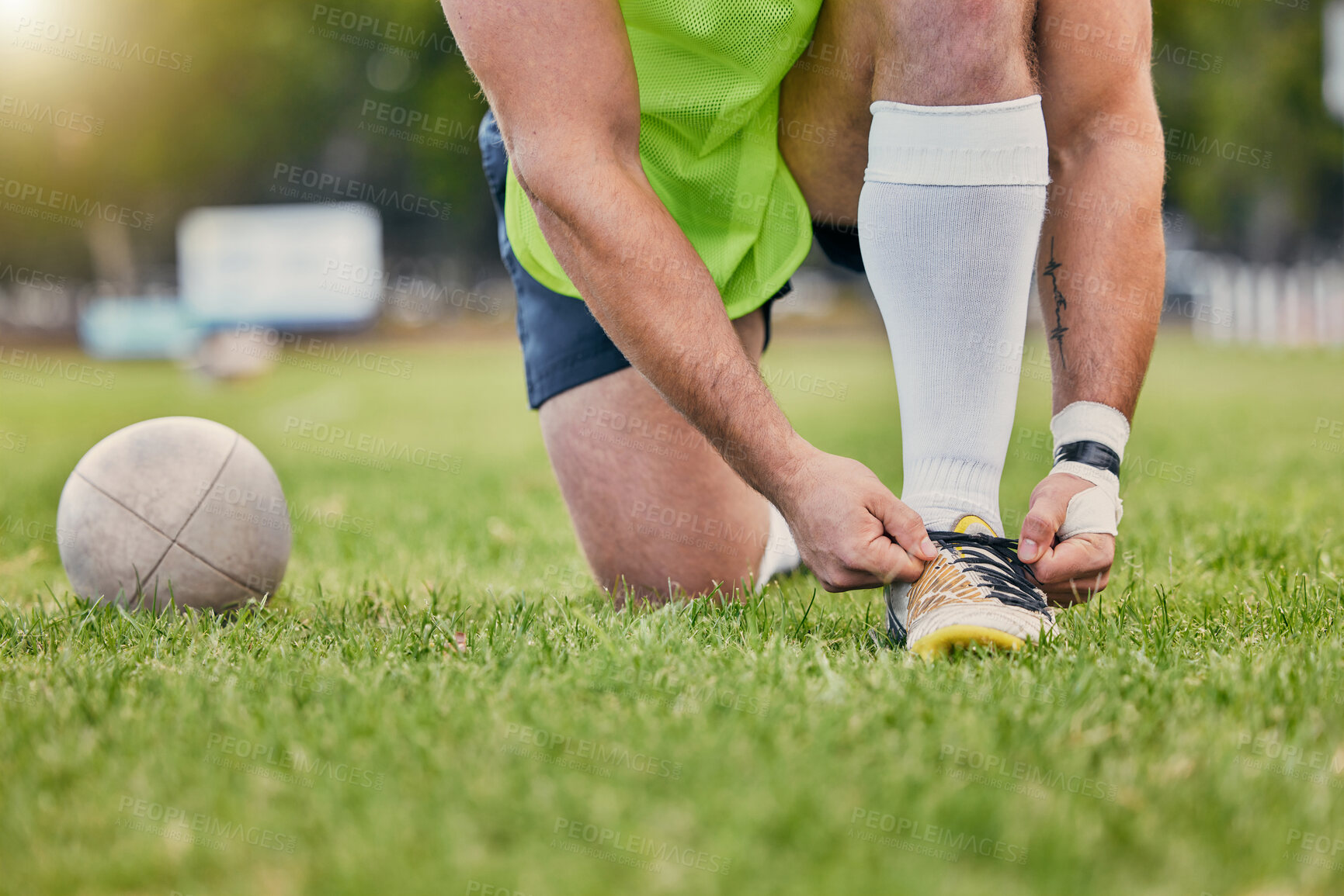 Buy stock photo Rugby ball, hands and tying shoe lace on grass field getting ready for sports match or game outdoors. Hand of sporty man tie shoes in preparation for sport, performance or motivation in park