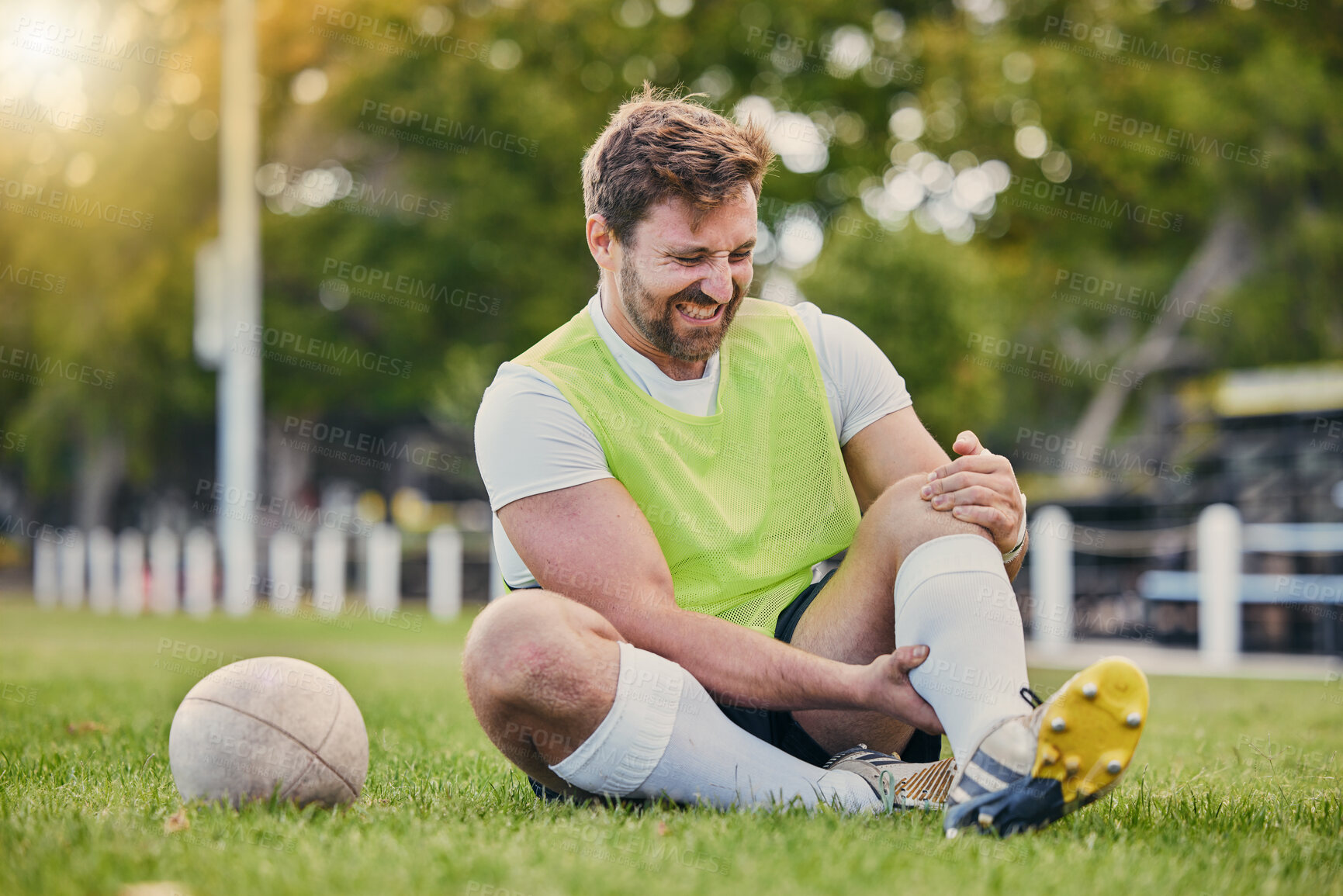 Buy stock photo Football, man and knee pain on grass field, inflammation and bruise with training, workout and exercise. Male player, athlete or guy on ground, leg injury and health issue with practice and emergency