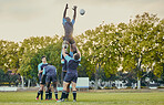 Sport, men and rugby and jump with team on field, playing game with energy and fitness, ball and action outdoor. Training, exercise and professional match, sports club with male group and active