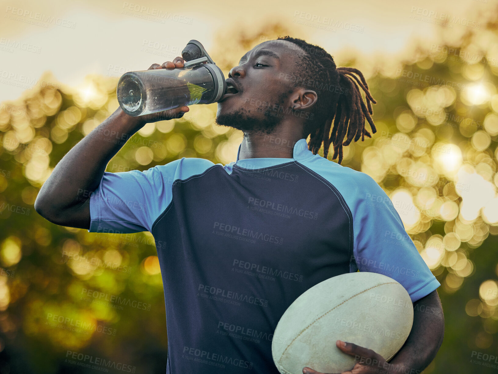 Buy stock photo Drinking water, fitness and rugby with a sports black man outdoor for a competitive game or event. Exercise, training and health with a male athlete taking a drink from a bottle during a break