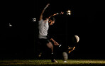 Rugby, night and man kicking ball to score goal at dark stadium at game, match or practice workout. Sports, fitness and motion, player with blurred action on grass with energy and skill in team sport