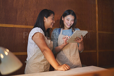 Buy stock photo Cafe, tablet and happy asian women at counter together checking sales, booking or menu for small business. Social media, food review and startup restaurant owner with waitress scroll on digital app.