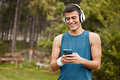 Buy stock photo Fitness, headphones and a man outdoor with a phone listening to music with banner. Happy runner, athlete or sports person in nature park to start exercise, workout or training while streaming radio