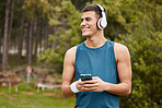 Phone, headphones and a man thinking of fitness outdoor or  listening to music with banner. Happy runner, athlete or sports person in nature to start exercise, workout or training and streaming radio