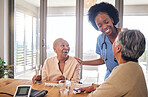 Doctor with senior women at table in nursing home for consultation, check up and conversation. Nurse, caregiver or medical professional with elderly patient in living room for advice, chat and care. 