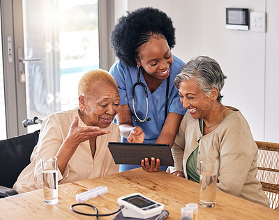 Buy stock photo Tablet, smile and an assisted living nurse with old women in the kitchen of a retirement home for consulting. Technology, medical and an african caregiver showing information to patient friends