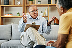 Senior man speaking to a psychologist at mental health, psychology and therapy clinic for session. Psychological therapist with clipboard for counseling checklist with elderly male patient in office.