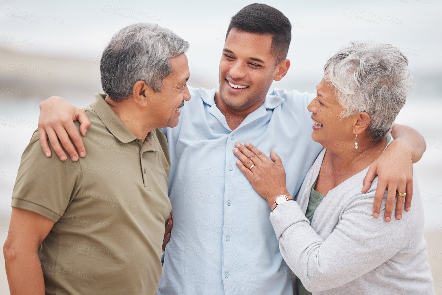 Buy stock photo Man, senior parents or laughing at beach for bond, support or love with smile, care or pride in retirement. Hug, father or mature mother with a happy son at sea together on family holiday vacation