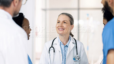 Buy stock photo Mature woman, doctor and team planning with smile, leadership and mentor to interns at hospital. Happy medical professional, support and teaching students on healthcare, wellness and treatment 