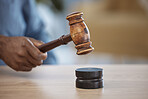 Gavel, hand of lawyer or judge in office for decision, attention or legal advice in justice system. Hammer, desk and man in courtroom, law firm or government agency to stop hearing in human rights.