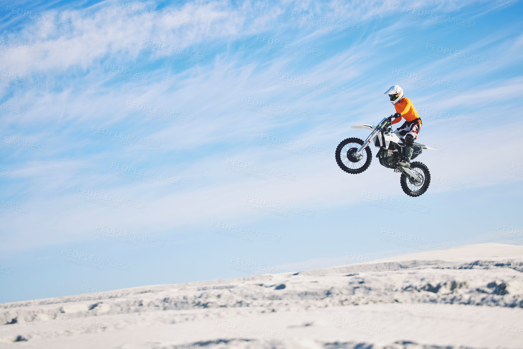 Buy stock photo Motorcycle, desert and jump for sports in race, adrenaline and training for fitness in competition. Athlete, sky and mockup for freedom, driving and dirtbike in outdoor for stunt or performance